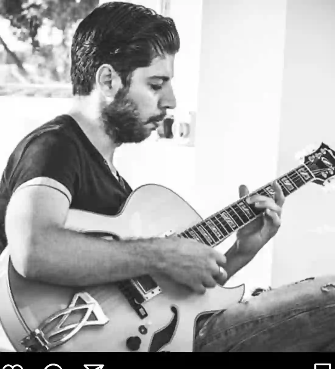 Carmelo Gattuso ritratto in bianco e nero mentre suona la chitarra archtop