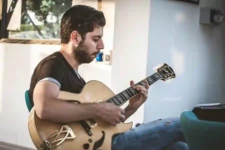 Carmelo Gattuso con la sua chitarra archtop, fotografia a colori in ambiente naturale